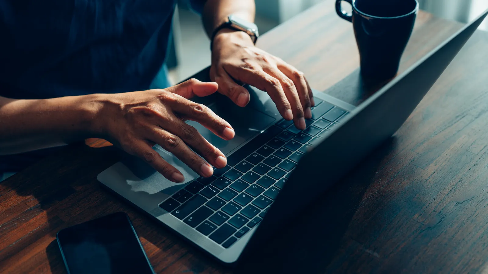 Persona trabajando en su notebook mientras revisa la protección de datos de su empresa